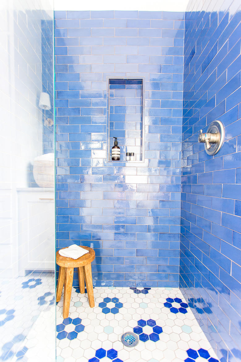 blue bathroom with subway wall tile and hexagon floor tile