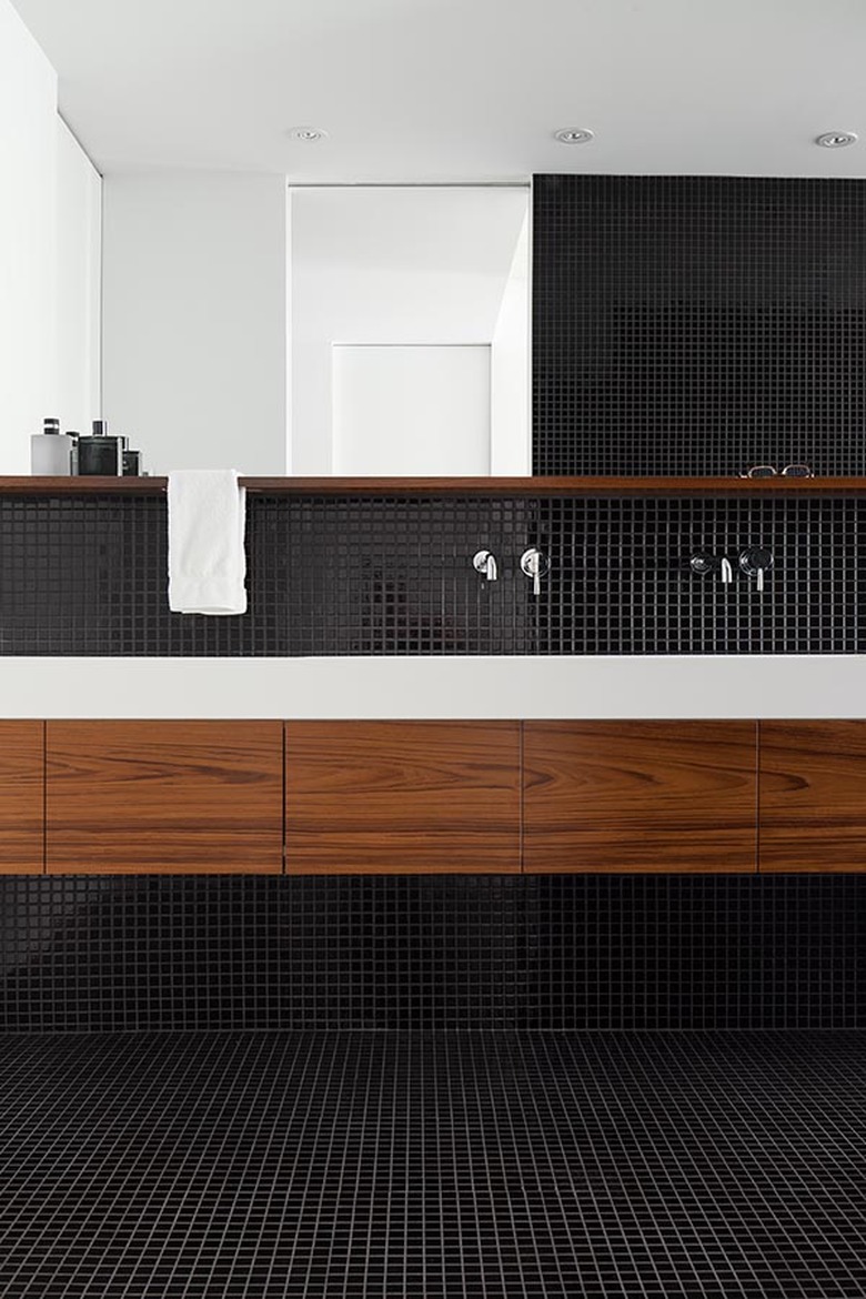 black bathroom with black mosaic floor and wall tile