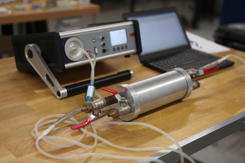 Radon gas radiation detectors testing. Dosimetrist holding a portable gamma radiation dosimeter set on a long tube with sample probe .