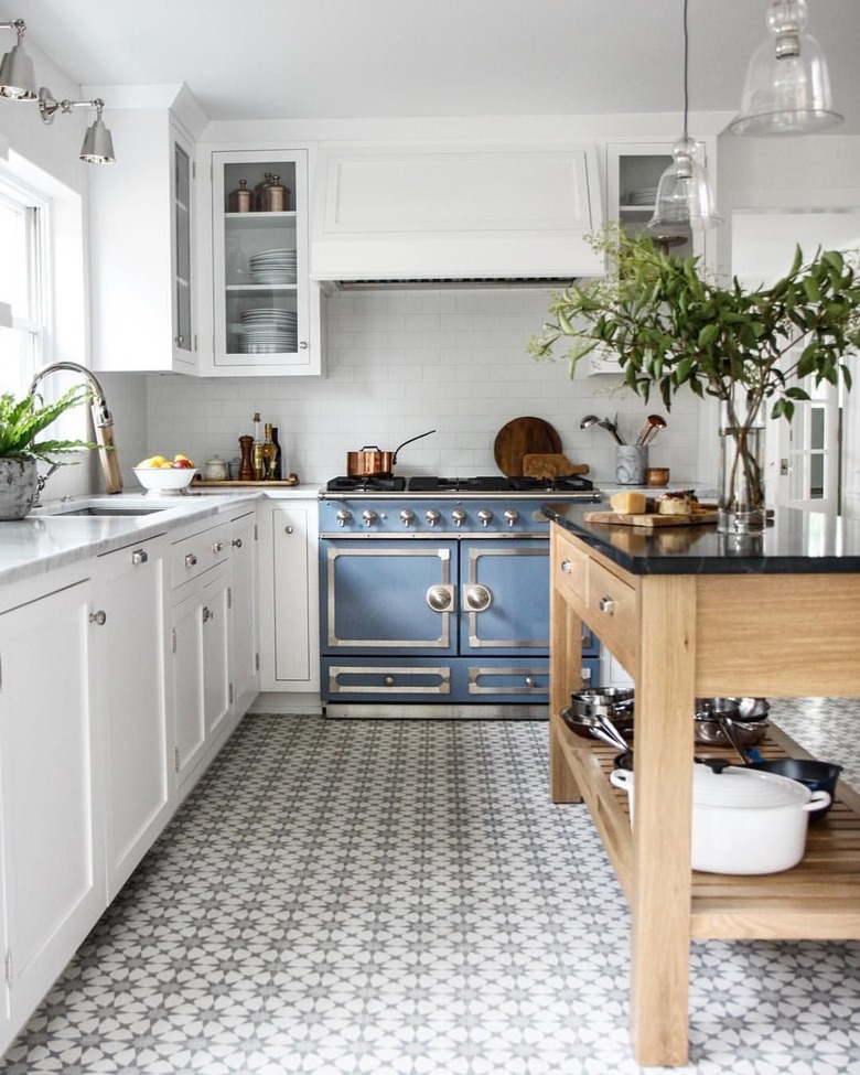 white kitchen with tiled floors and blue oven