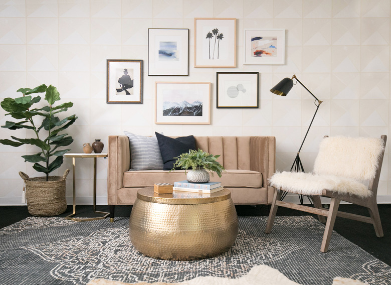 neutral wallpaper in a living room with channel tufted sofa and gallery wall