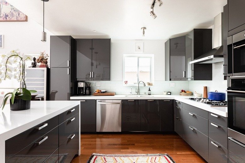 Kitchen with gray cabinets, white counters, and wood floors.