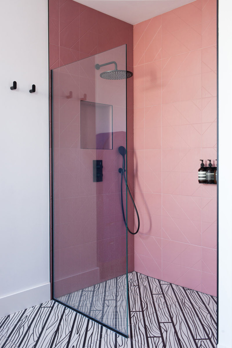 black rain showerhead in pink tile shower