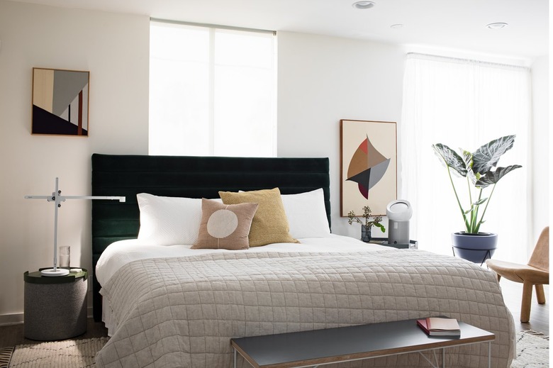 Bedroom with neutral and beige furniture with air purifier on nightstand