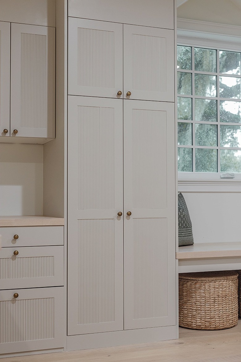 white reeded built-in cabinets with storage basket