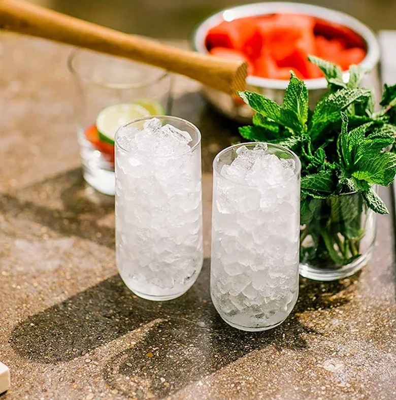 Nugget ice in two tall glasses near a jar of fresh mint