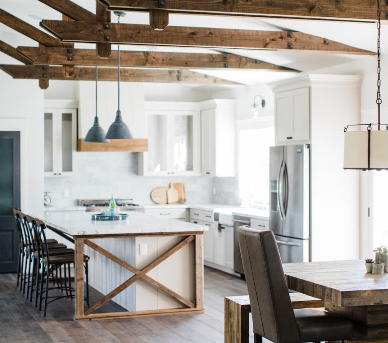 Farmhouse kitchen island idea with exposed ceiling beams and white cabinets with white countertops