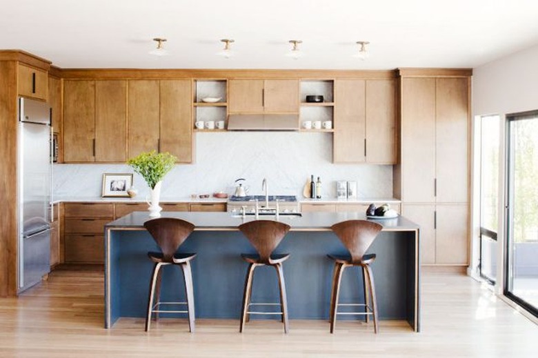 light wood kitchen cabinets with blue island and white countertops