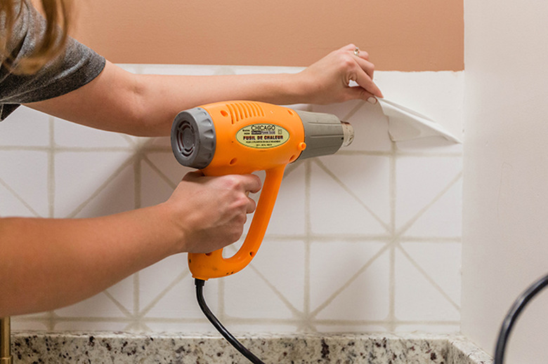 Use a heat gun to warm the surface of the peel-and-stick wallpaper.