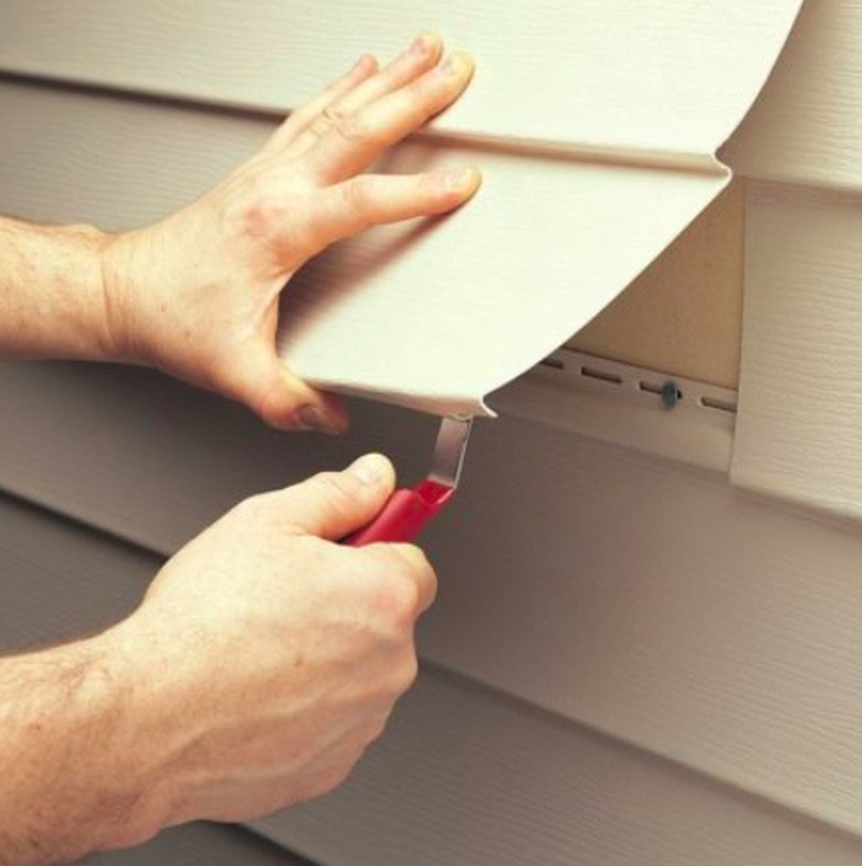 Removing vinyl siding.