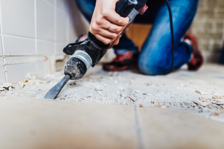 Woman removing old tiles.