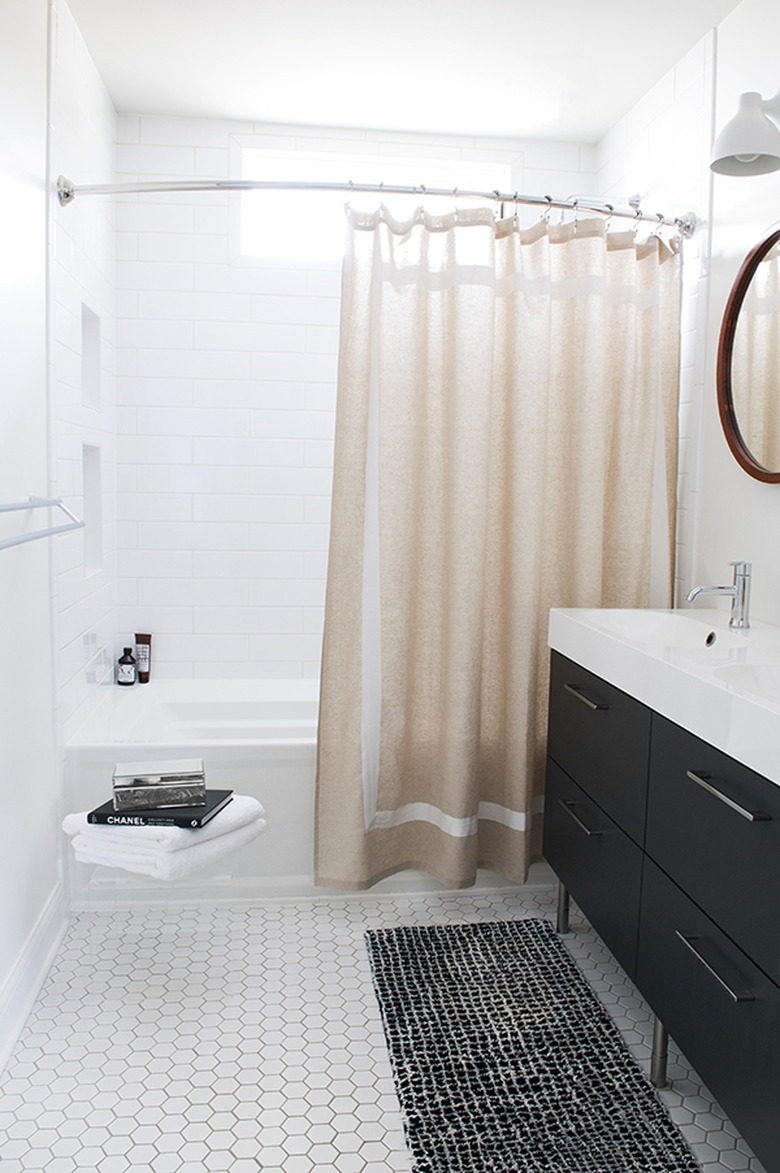 black-and-white bathroom idea with neutral shower curtain and tile flooring