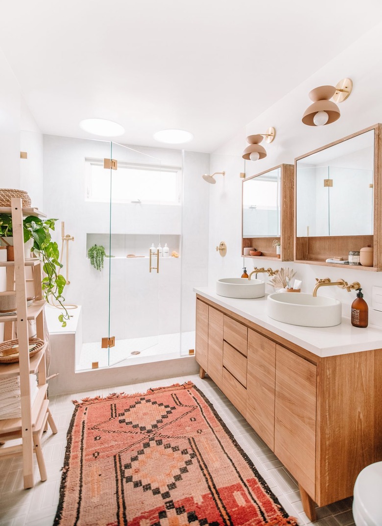 bathroom idea with rug and wood vanity cabinet next to walk-in shower