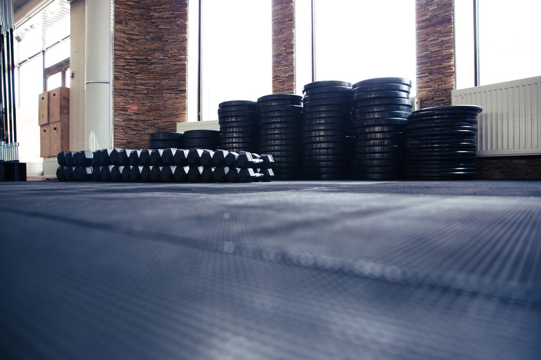 Ground view of a mat with weights and barbells in a gym