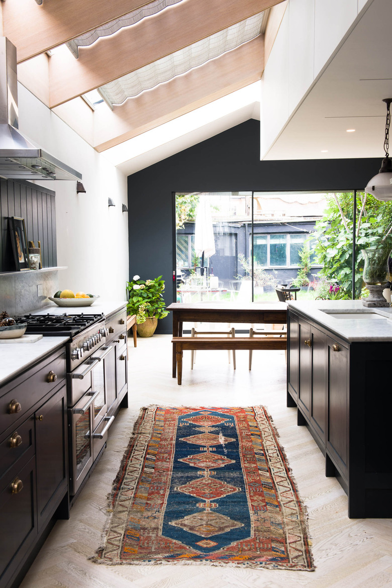 vintage navy and orange rug for kitchen floor with black cabinets