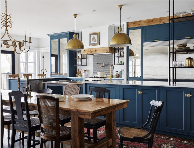 Rustic blue kitchen with wood table and gold pendant lights