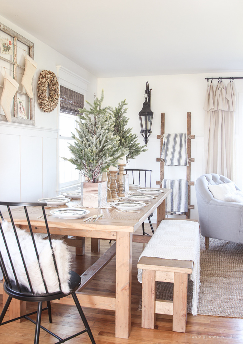 Rustic Christmas decorations in dining room with wood furniture and pine trees