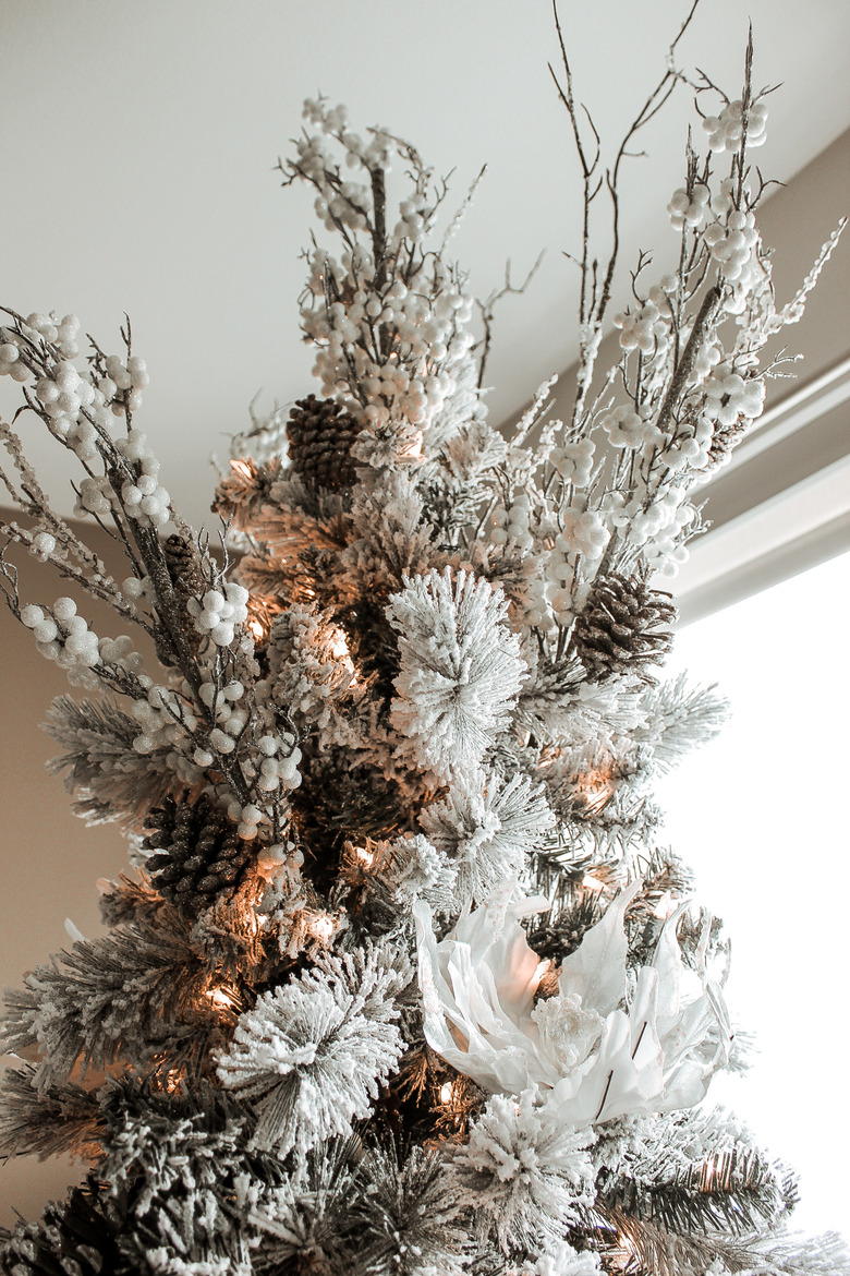 Rustic Christmas tree with pinecones, white flowers, and branches