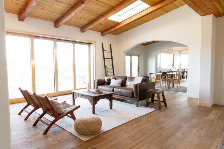 rustic decor with hardwood floors, exposed wood ceiling beams, and skylight in living room