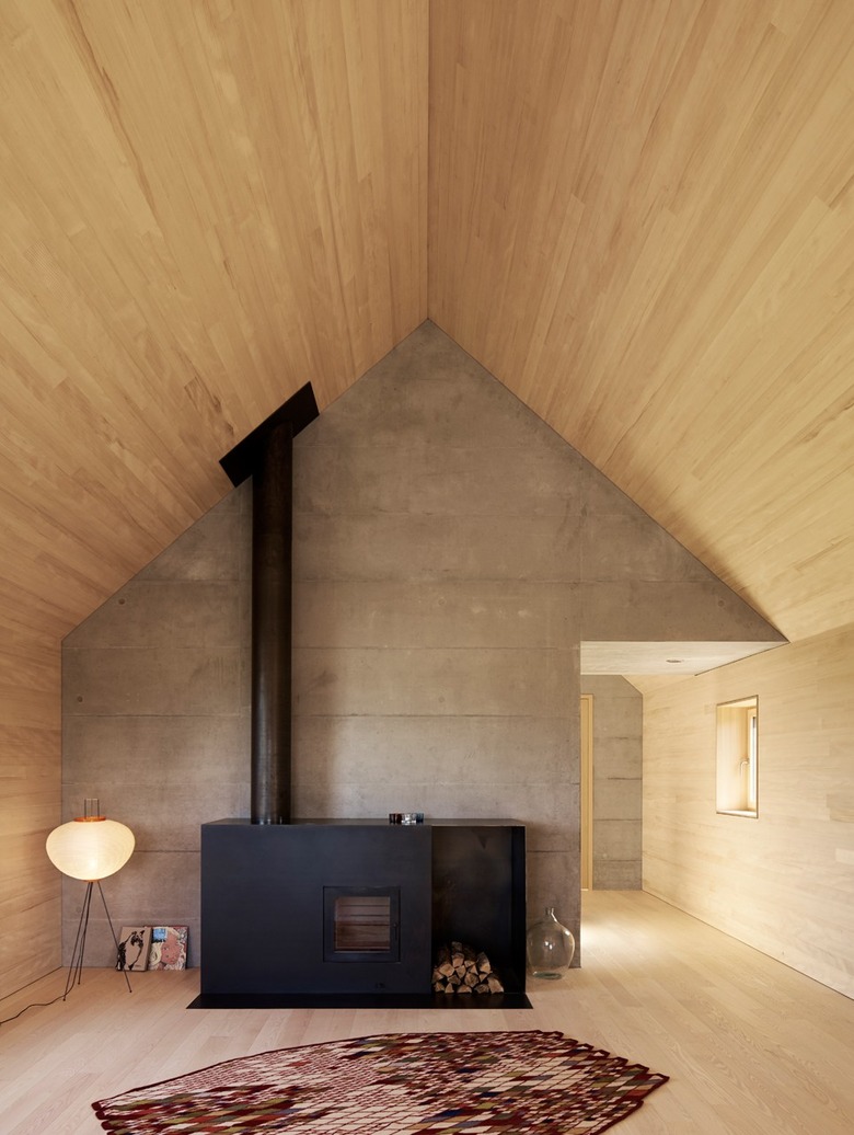 black metal fireplace with chimney and wood storage