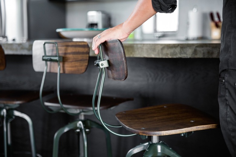 rustic industrial decor with wood and metal schoolhouse style barstools, dark finish bar.