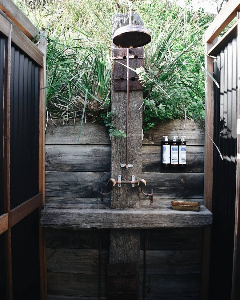 Rustic shower idea with reclaimed wood, worn plumbing fixtures, and plants