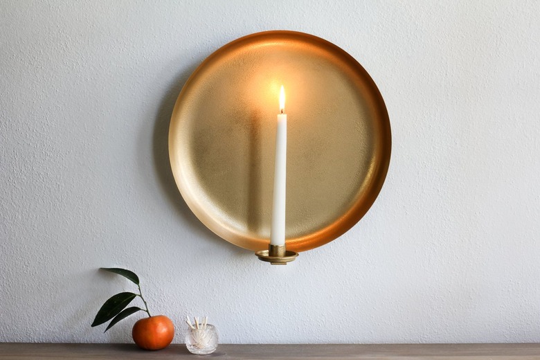 Wall sconce with candle with tangerine and container of matches