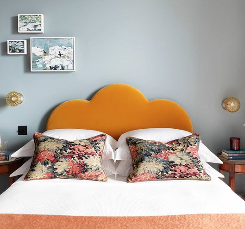 Scandinavian bedroom idea with Orange scalloped velvet headboard with bluish-gray walls and wall sconces