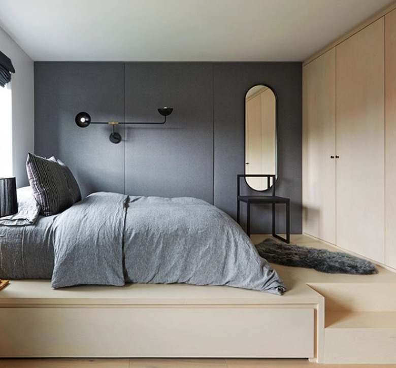 Scandinavian bedroom idea with bleached wood room and gray accents with upholstered wall panels and modern accents