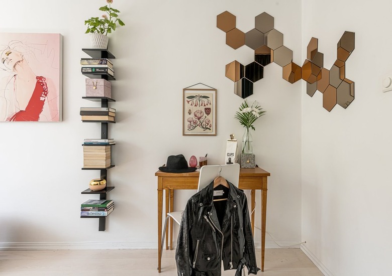 scandinavian style office with mirrored wall and floating shelves