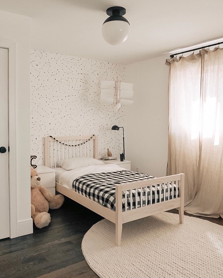 black and white Scandinavian kids bedroom idea with drapery at window and circular area rug