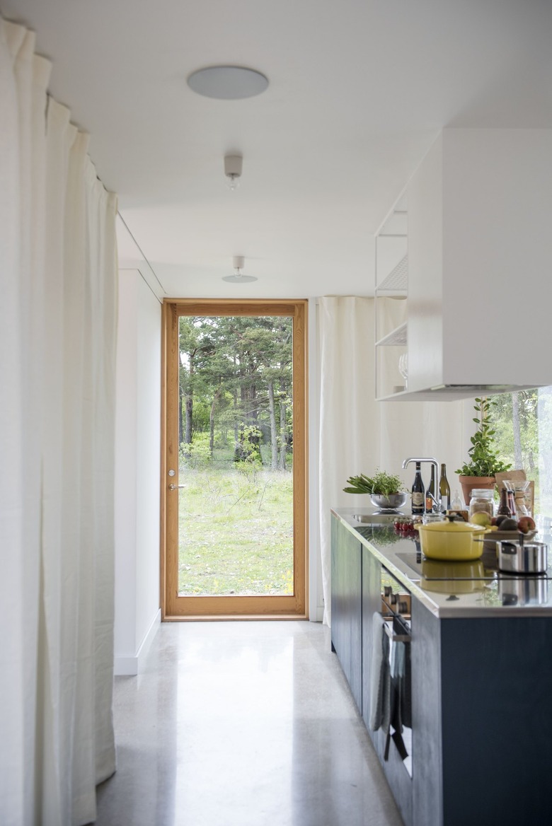 a long narrow kitchen island with a glass door to the outside