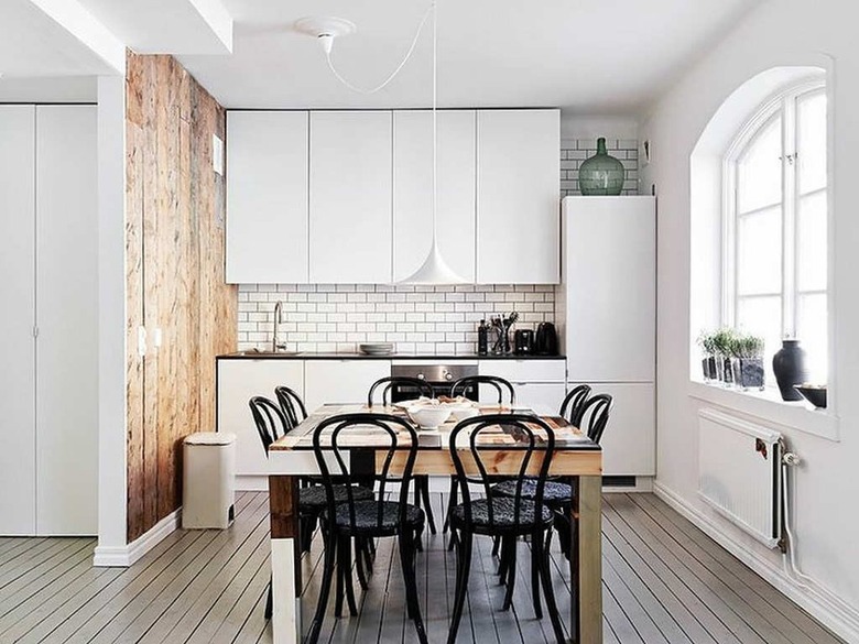 white scandinavian kitchen with subway tile and wooden dining table in the middle