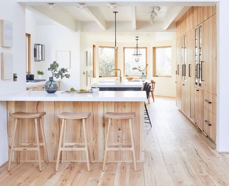 white scandinavian kitchen with wooden floors and cabinets