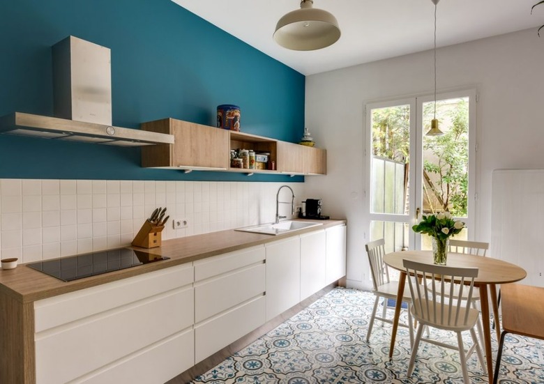 Scandinavian kitchen floor tile with pattern and white cabinets with wood countertop