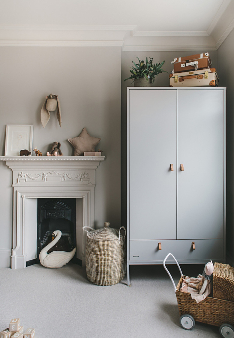 Scandinavian baby nursery idea with storage cabinet and woven baskets for toys