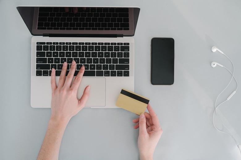 laptop and hand holding credit card