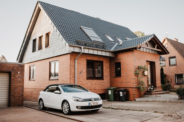 brick house and white car