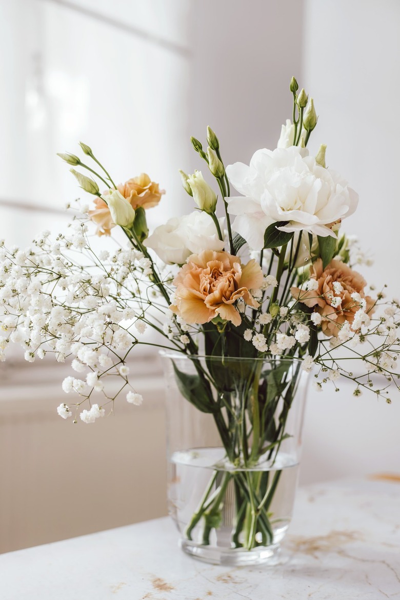 Glass vase with peach and white flowers