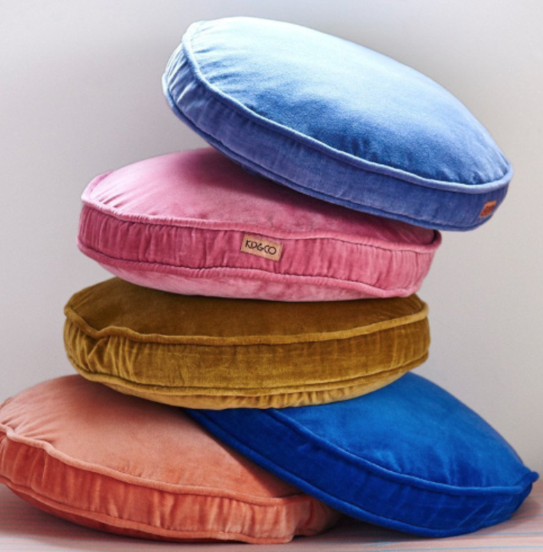 Round velvet throw pillows in light blue, pink, gold, royal blue and orange.