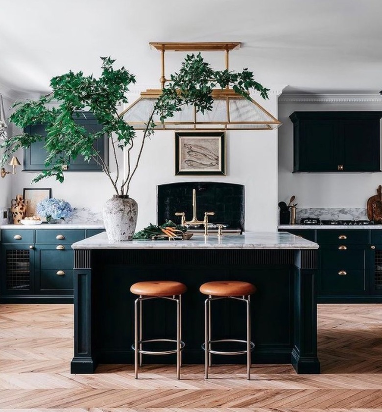 Kitchen with black and marble kitchen island and large plant