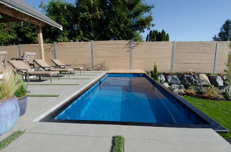 A shipping container pool built into a concrete pool deck.