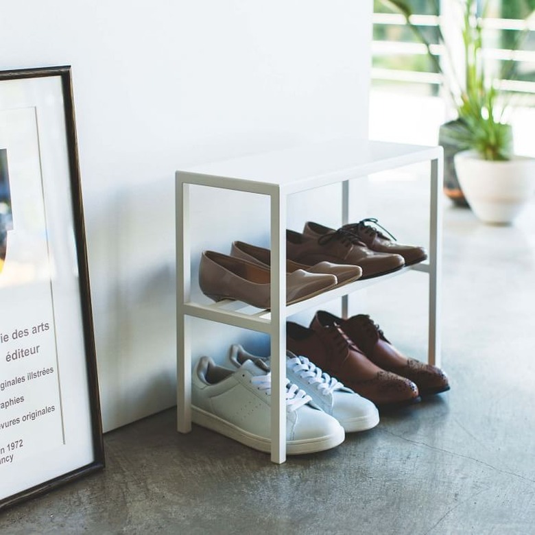 White metal shoe organizer, shoes, concrete floors.