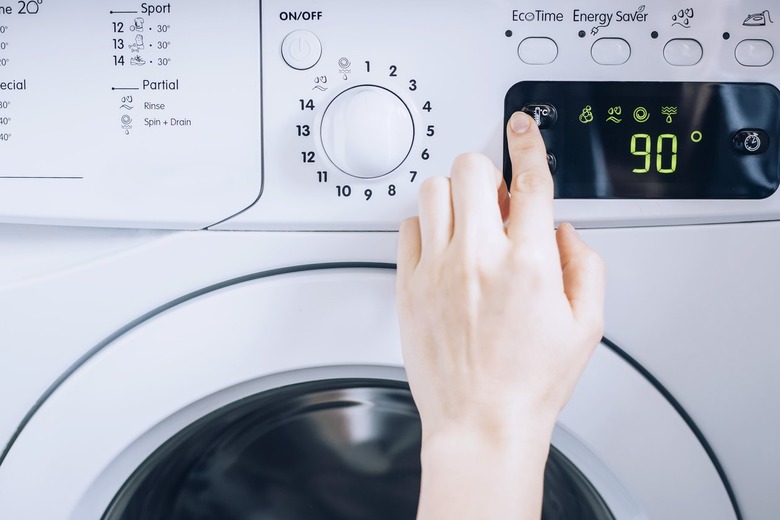 Hand selecting 90 degrees on the setting for white clothing dryer