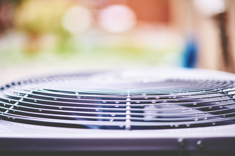 Air conditioner unit with raindrops in residential garden