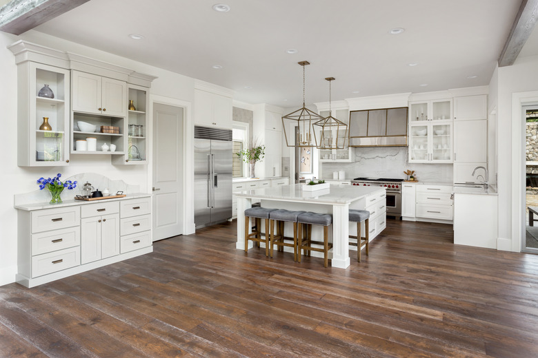 beautiful kitchen in new luxury home with island, pendant lights, and hardwood floors