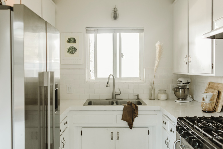 small white kitchen with stainless steel fridge and double bowl sink