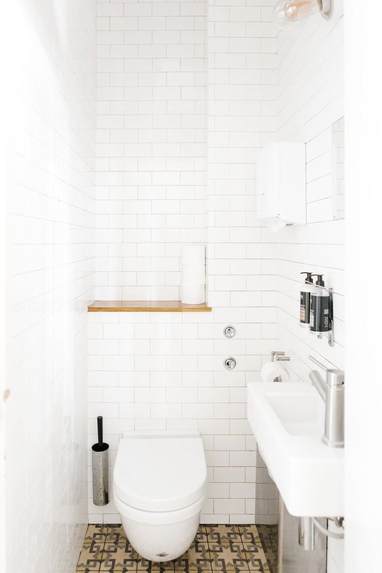 Minimalist bathroom with white tiled walls and neutral mosaic tile floors