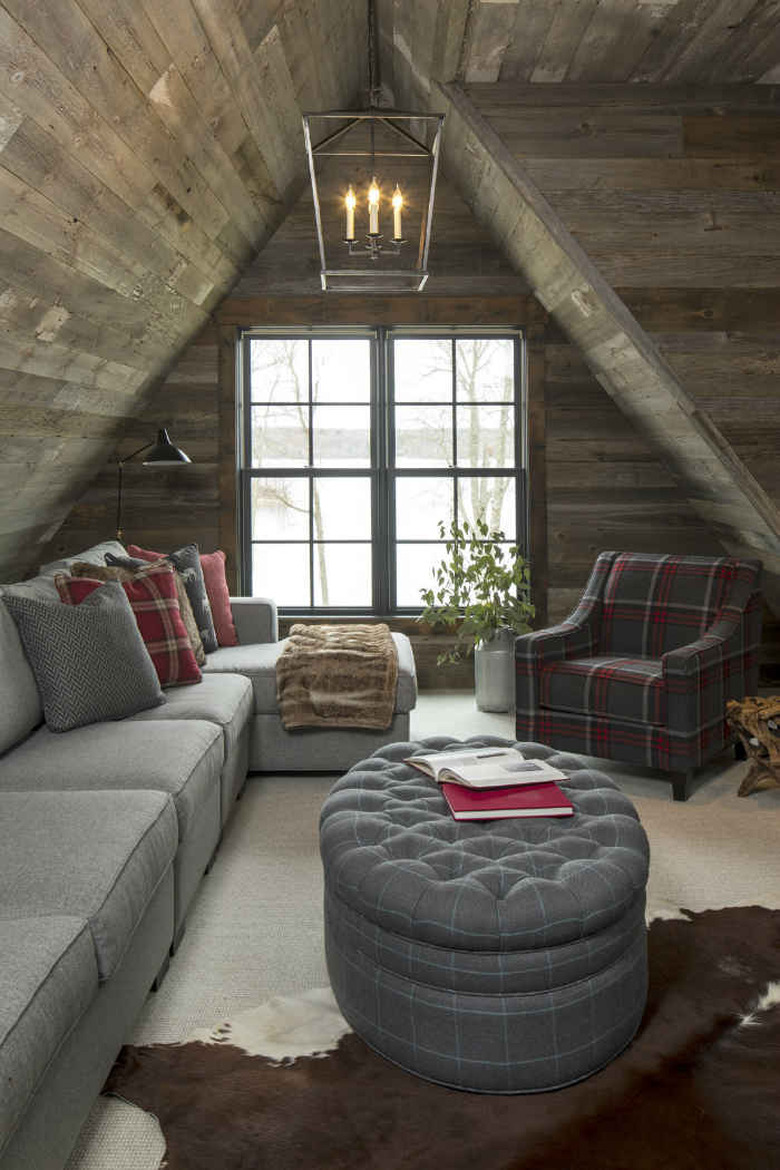 Small attic ideas for a space with high angled roof and wooden paneling along the ceiling.