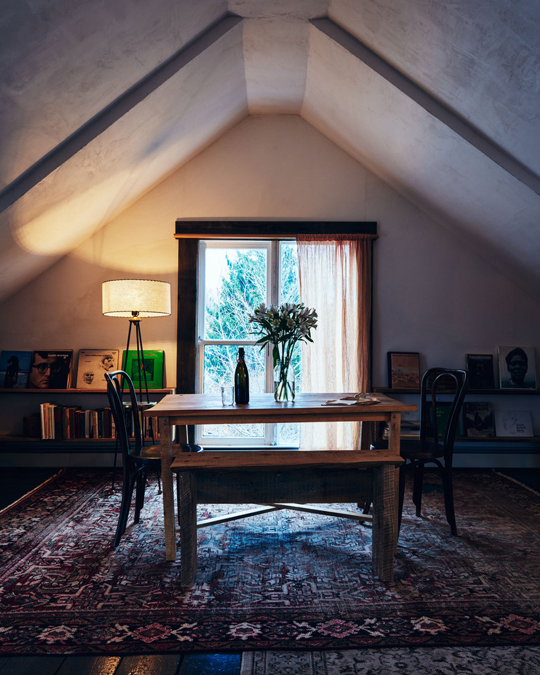 small attic library with floating shelves and table